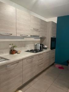 a kitchen with wooden cabinets and a stove top oven at Joli Appartement proche centre ville in LʼÎle-Rousse +1 photo