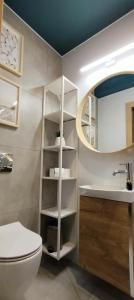 a bathroom with a toilet and a sink and a mirror at Cicha Przystań - Pokoje Przy Latarni in Kołobrzeg