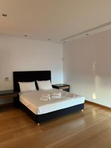 a bedroom with a large bed with white sheets at Sunset Villa in Saronida