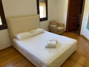 a bedroom with a bed with two towels on it at Sunset Villa in Saronida +29 photos