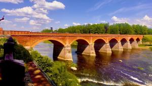 a large bridge over a river with a river at Mucenieku Apartamenti in Kuldīga