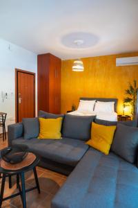 sala de estar con sofá azul y almohadas amarillas en Desert Oasis by Heaven's Hall, en Alexandroupoli
