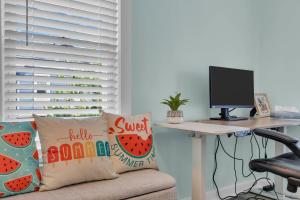 an office with a desk with a computer monitor at 6-Min Walk to Asbury Park & OG Main St - Updated & Cozy Apartment in Historic Ocean Grove - Fire Pit & Patio - Fast Wi-Fi in Ocean Grove +31 photos