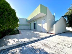 a white house with a large driveway at Helios in Kos Town