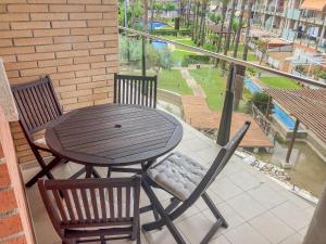 a wooden table and chairs on a balcony with a view at Apartamento con piscina, terraza y parking gratis "Ideal familias" Cambrils in Cambrils +27 photos