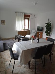 a living room with a table with chairs and a couch at la maison des fleurs in Fenis