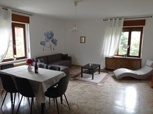 a living room with a table and a couch at la maison des fleurs in Fenis