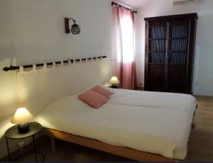 una camera da letto con un grande letto bianco con due lampade di Villa avec vue sur la mer à Sari-Solenzara, piscine privée a Sari Solenzara Altre 18 foto
