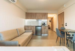 a living room with a couch and a kitchen at Elysium Seaside in Loutsa