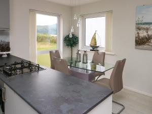 cocina con encimera negra y mesa en Sunset Sands, en Conwy 22 fotos más
