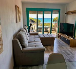 ein Wohnzimmer mit Sofas, einem TV und einem Balkon in der Unterkunft Apartamento Malgrat de mar in Malgrat de Mar