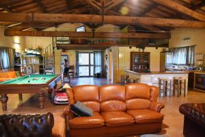 a living room with a leather couch and a pool table at Vigna Di Valle in Bracciano