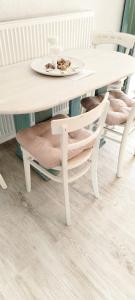 a white table and chairs with a plate on top at Apartment BoNo in Šmrika +10 photos