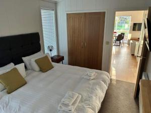 a bedroom with a large white bed with towels on it at Homili Lodge in Eyemouth
