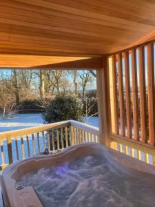 a hot tub on the deck of a house at Homili Lodge in Eyemouth +2 photos