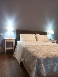 a bedroom with a large bed and two lamps on tables at Peti's Apartment in Prinos