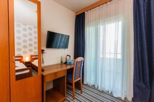 カシュテラにあるairport rooms Manufakturaのデスクとベッドルームが備わるホテルルームです。