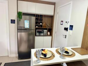 a kitchen with a table and a refrigerator at Apartamento Decorado na Serra em Itaipava in Petrópolis
