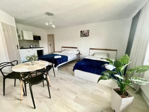 a bedroom with two beds and a table and a table and chairs at Madi Apartamenty in Sandomierz
