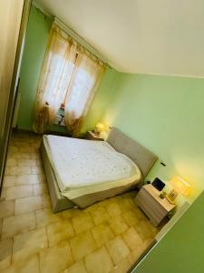 a bedroom with a large bed in a green room at Villetta a schiera indipendente in Castagneto Carducci