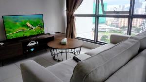 a living room with a couch and a flat screen tv at Pool Haven Reservations in Kuala Lumpur