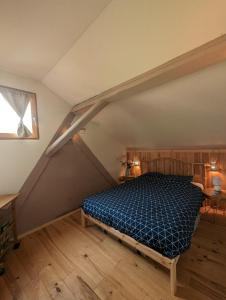 a bedroom with a blue bed in a attic at La grange de la petite souris in Bouxwiller