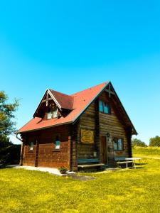 a wooden house with a red roof in a field at Haus Lahneck bei Koblenz in Lahnstein