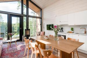 a kitchen and dining room with a wooden table and chairs at Himos Frame in Jämsä