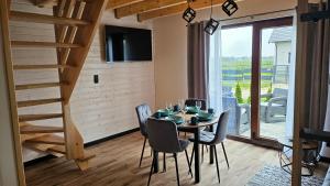 a dining room with a table and chairs and a staircase at Domki U Sieronia in Mielenko