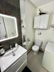 a white bathroom with a sink and a toilet at Charmant studio Horizon & Océan in Anglet