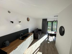 een keuken met witte kasten en een tafel in een kamer bij Apartamenty La Venda in Darlowko