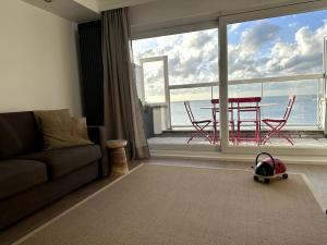 a living room with a couch and a table and chairs at Terrasse des Dunes in Knokke-Heist +3 photos