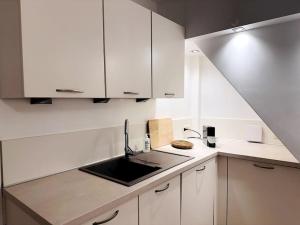 a kitchen with white cabinets and a sink at Terrasse des Dunes in Knokke-Heist
