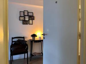 a room with a chair and a table with a lamp at Terrasse des Dunes in Knokke-Heist