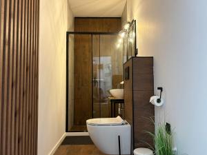 een badkamer met toilet en glazen douche bij Apartamenty La Venda in Darlowko +116 foto's