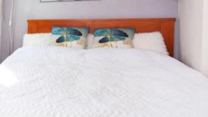a white bed with blue pillows on top of it at Casa Son Juvera Andratx in Andratx