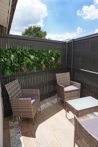 Un patio con sillas y mesas y una valla. en Maison 2 chambres avec terrasse, en La Roche-sur-Yon