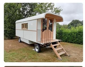 a tiny house on a trailer with a ladder at La roulotte des Trois Arbres in Oradour-sur-Glane