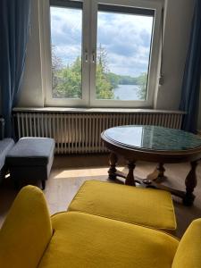 a living room with a table and a window at Altes Seeblickjuwel in Eutin