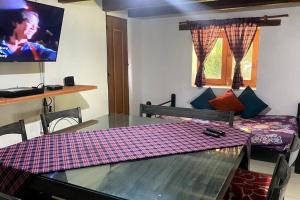 a dining room with a table and a tv at Cabaña 1111 in Valle de Bravo