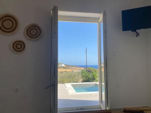 a door with a view of a pool and the ocean at Yannis Boutique Cycladic House in Kampos Paros