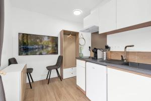 a kitchen with white cabinets and a counter top at L Atmosphère Tendre in Toulouse