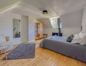 a bedroom with a bed and a couch and a window at Le Lampadaire du Martreuil in Pierrefonds