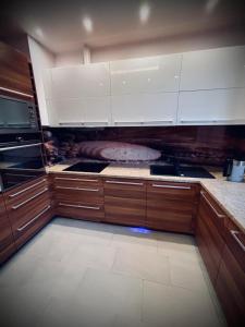 a kitchen with wooden cabinets and white appliances at Apartament WHITE GLOVE Wojska Polskiego in Olsztyn