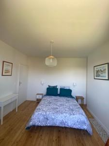 a bedroom with a large bed with blue pillows at La Hacienda Blanca in Saint-Jouan-des-Guérets