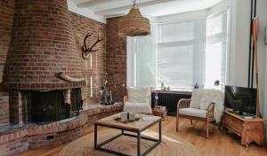 ein Wohnzimmer mit einer Ziegelwand und einem Kamin in der Unterkunft Have a nice stay! - Strand Vakantiehuis Noordwijk in Noordwijk aan Zee