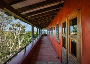 eine Veranda eines orangefarbenen Hauses mit einem Gehweg in der Unterkunft Luxury Ocean View Villa Esplendorosa in Jobal