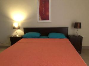 a bedroom with a bed with a red blanket and two lamps at 4 bedrooms 4 bathrooms Villa at the beautiful Ghazala Bay- North Coast - Egypt in Dawwār Abū Maḩrūs