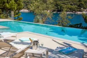 a swimming pool with a table and chairs next to a swimming pool at Villa Mila in Selca