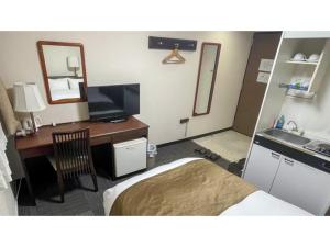 a hotel room with a bed and a desk with a mirror at Takatsuki W&M Hotel - Vacation STAY 48546v in Takatuki +24 photos
